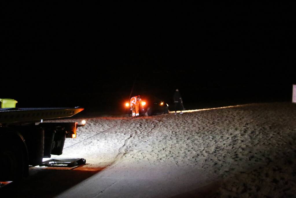Automobilist rijdt auto vast op strand