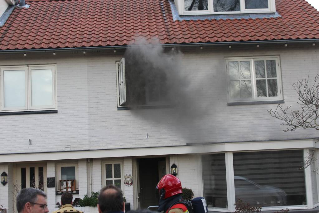 Zwarte rookwolken uit woning