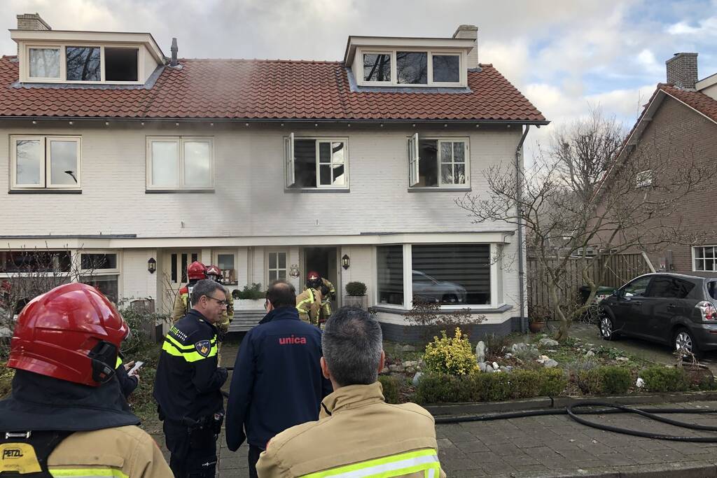 Zwarte rookwolken uit woning