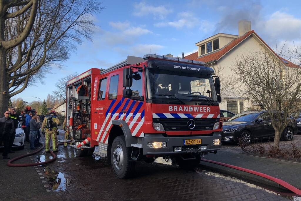 Zwarte rookwolken uit woning