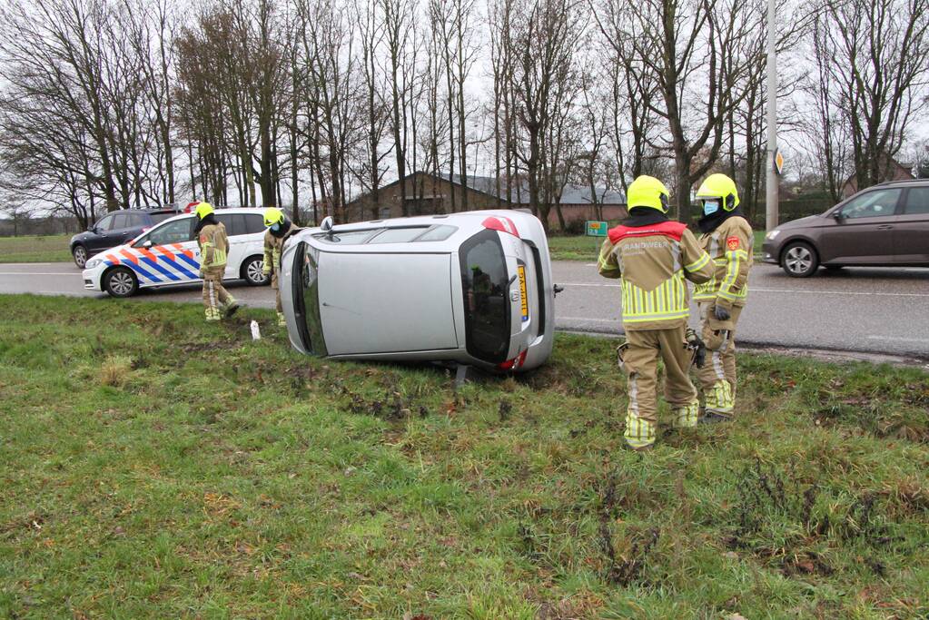 Auto belandt op zijn kant in berm
