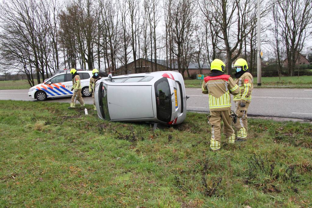 Auto belandt op zijn kant in berm