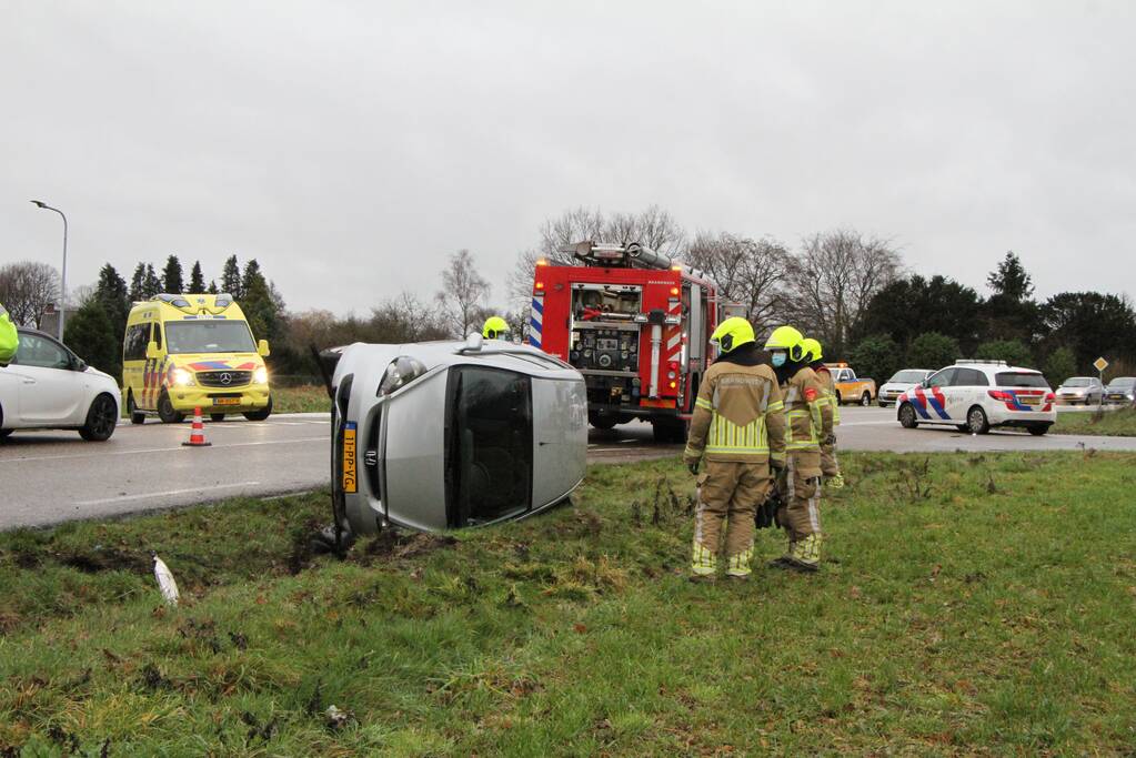 Auto belandt op zijn kant in berm