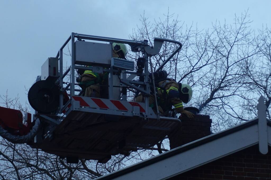 Brandweer veegt schoorsteen na brand