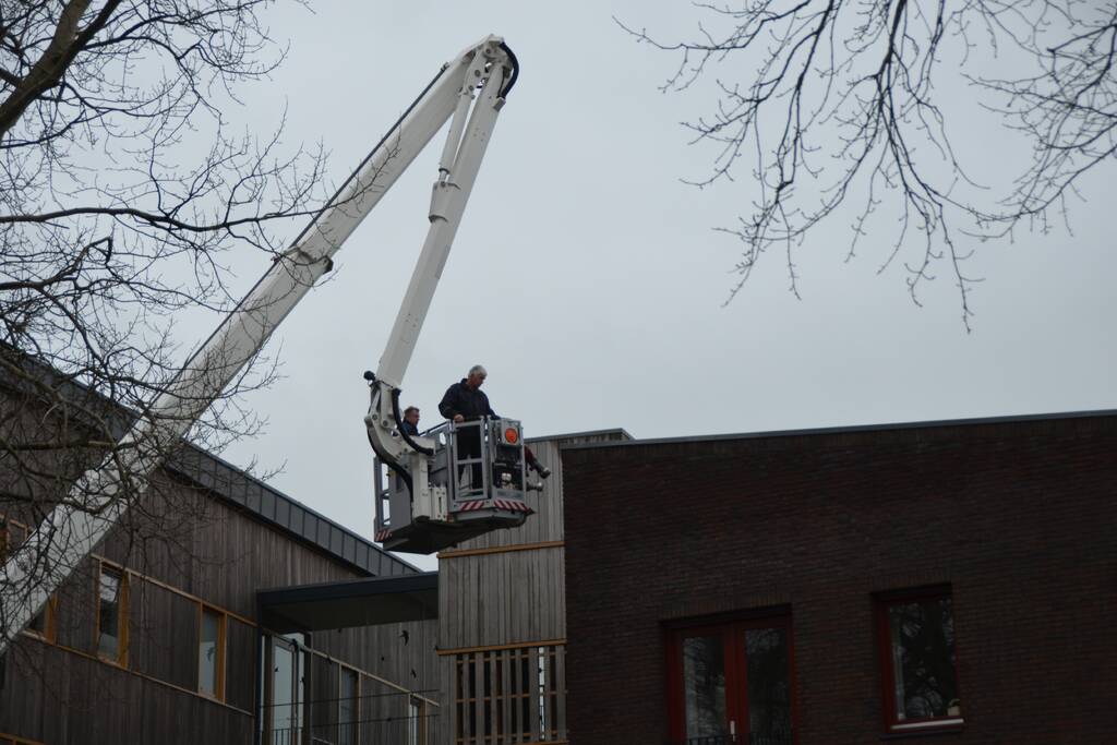 Zandzakken op dak pand door storm