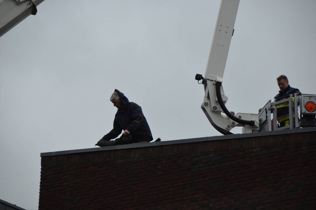 Zandzakken op dak pand door storm