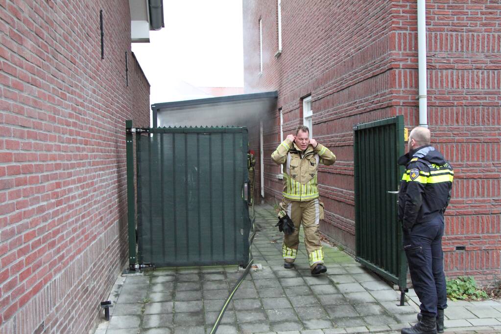 Brand onder overkapping van woning
