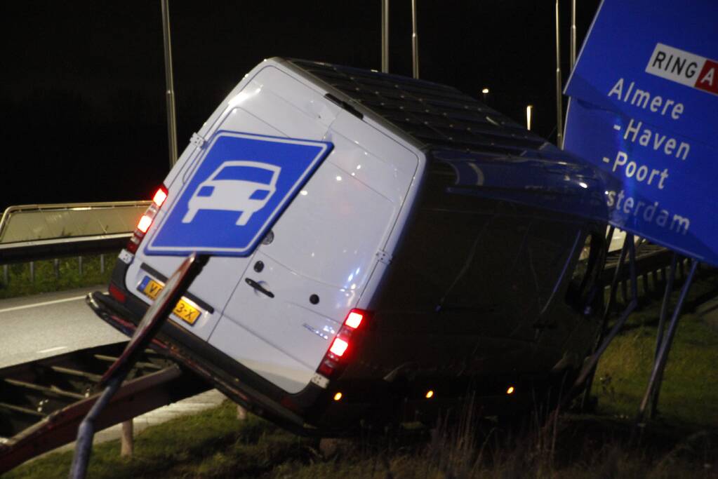 Bestelbus rijdt op vangrail en raakt verkeersborden