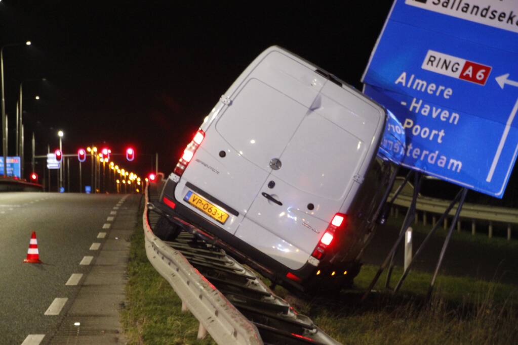 Bestelbus rijdt op vangrail en raakt verkeersborden