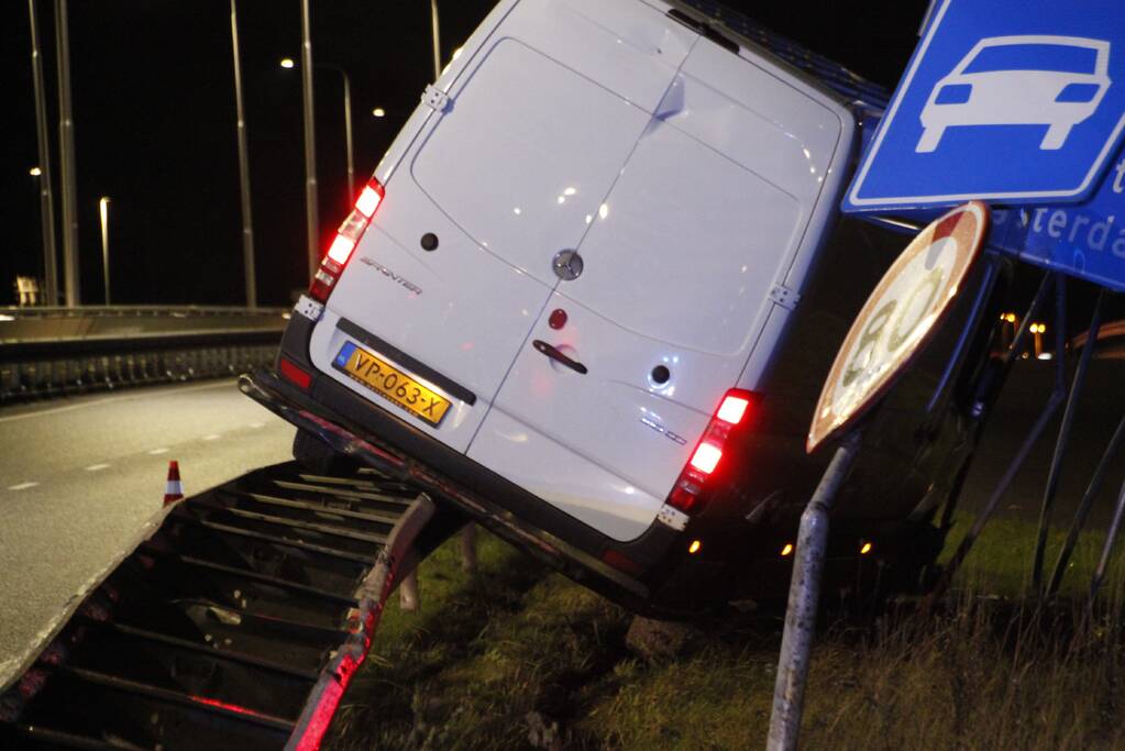 Bestelbus rijdt op vangrail en raakt verkeersborden