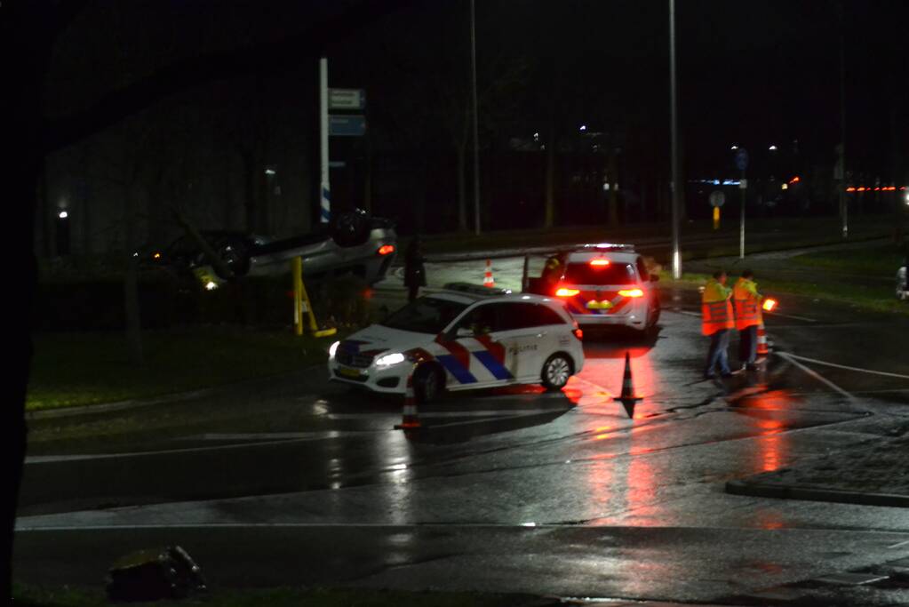 Auto belandt op de kop op rotonde