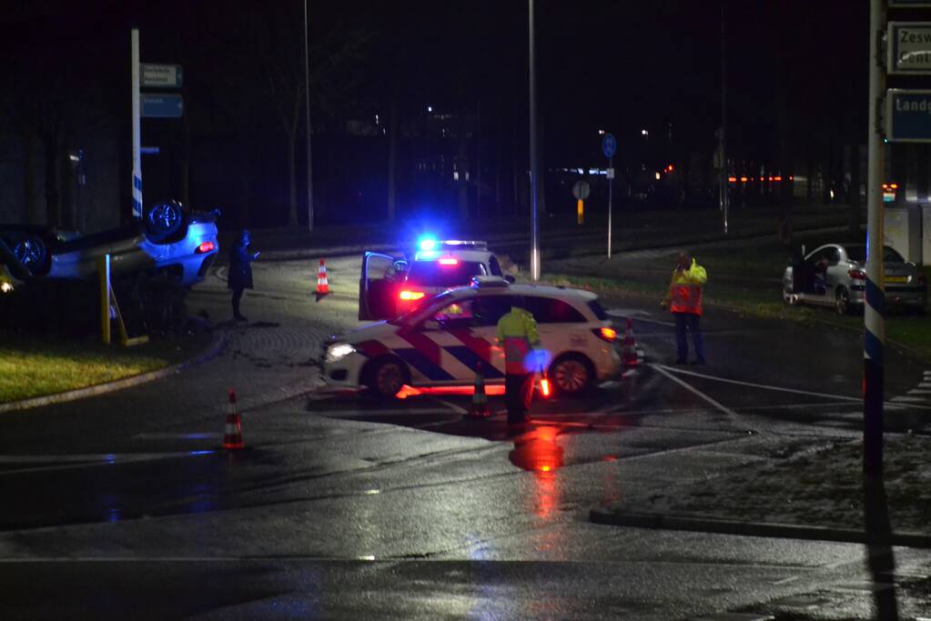 Auto belandt op de kop op rotonde