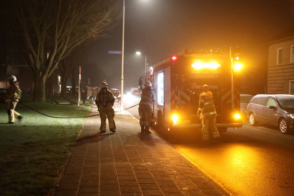 Hout en afval in brand tegen gevel