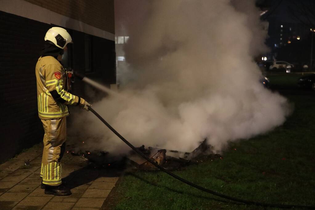 Hout en afval in brand tegen gevel