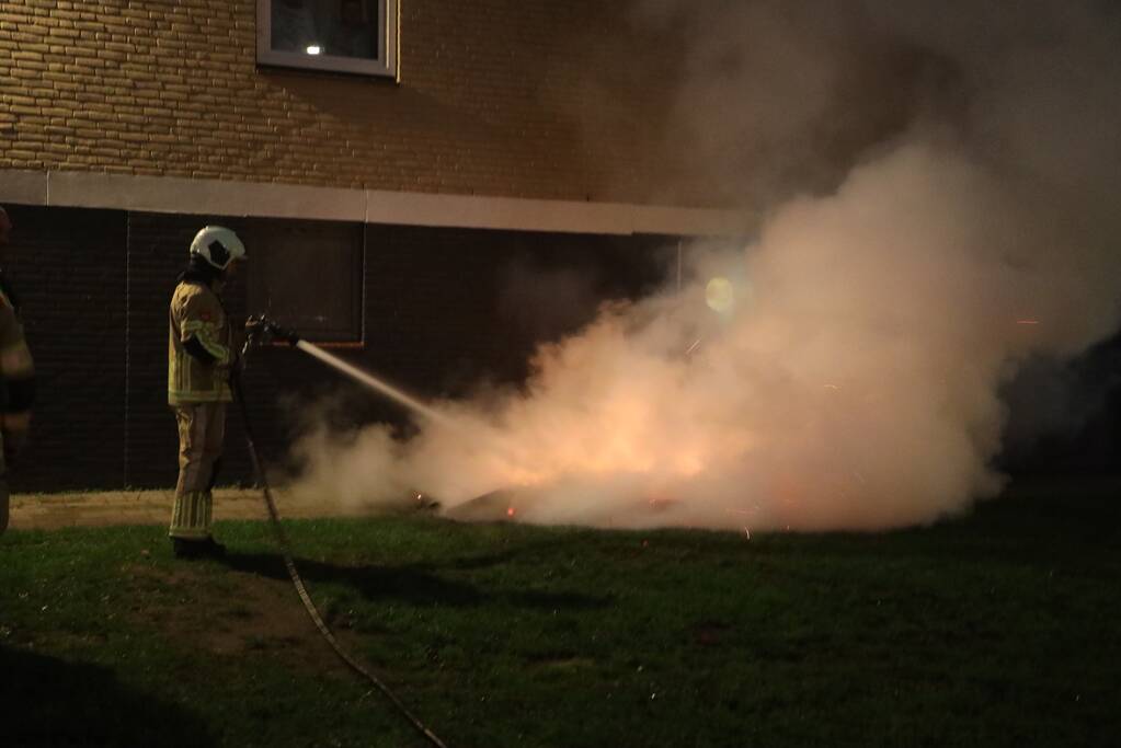 Hout en afval in brand tegen gevel