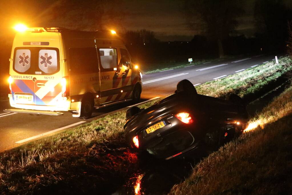 Auto belandt op dak in sloot