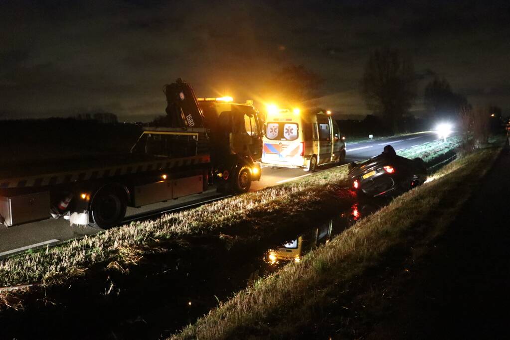 Auto belandt op dak in sloot