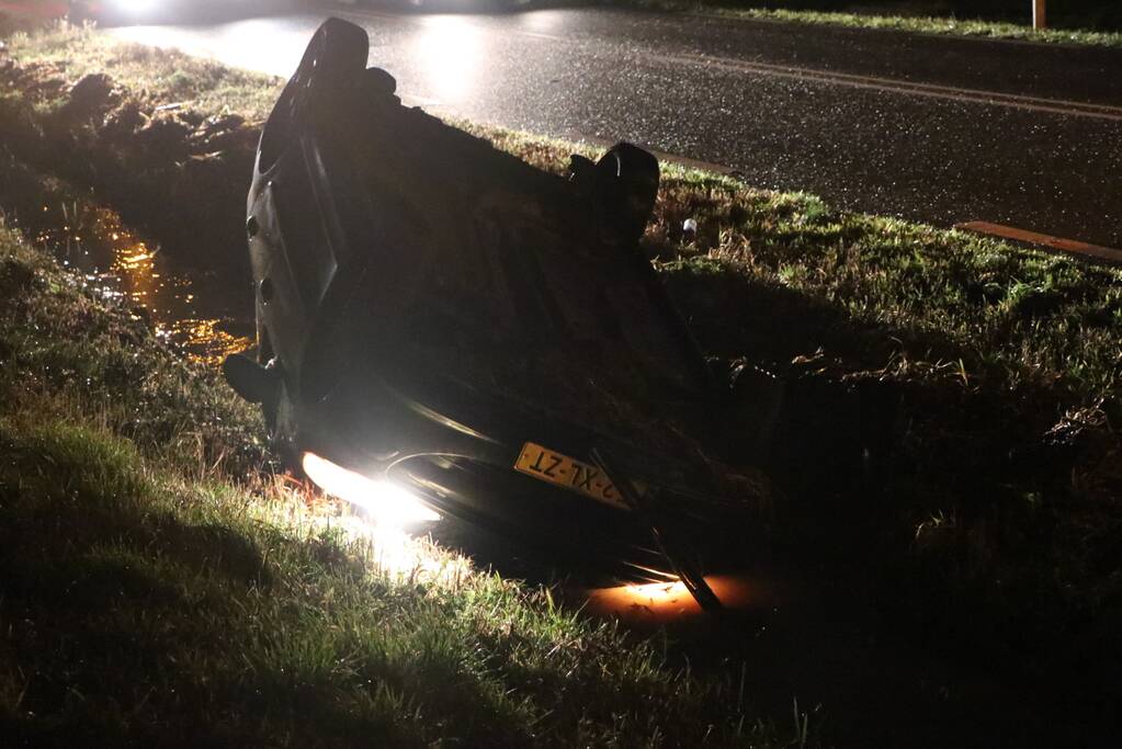 Auto belandt op dak in sloot