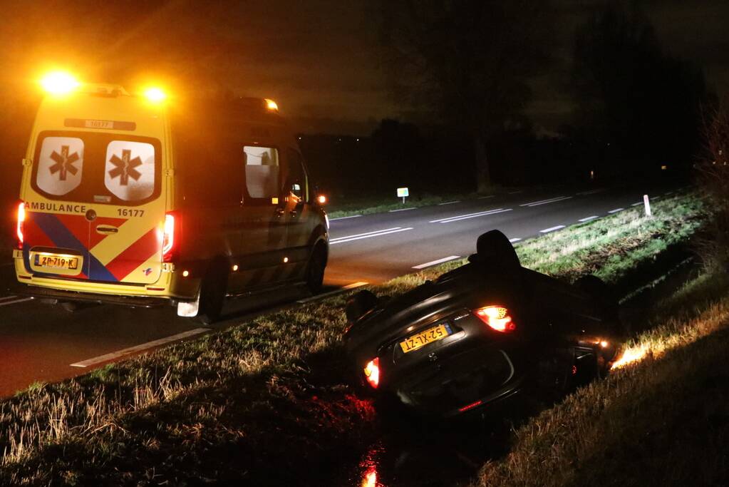 Auto belandt op dak in sloot
