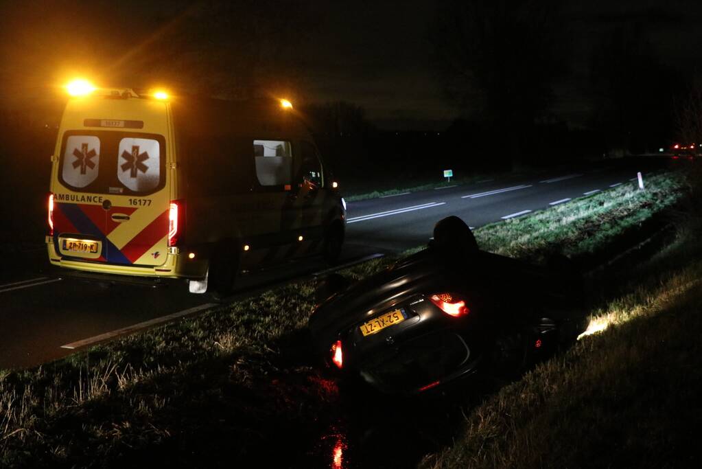 Auto belandt op dak in sloot