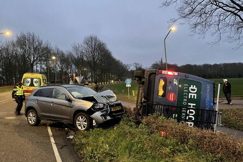 Bestelbus op zijn kant bij aanrijding
