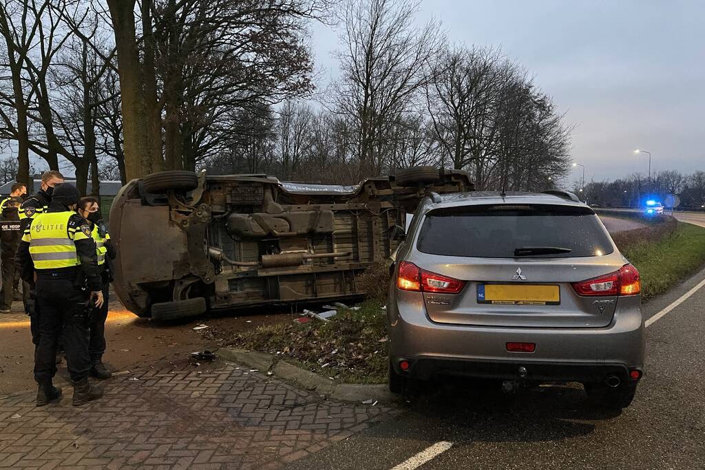Bestelbus op zijn kant bij aanrijding