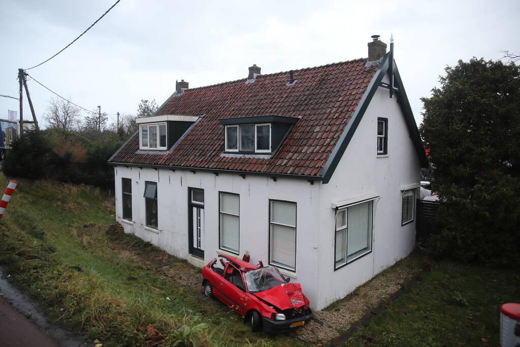 Auto rijdt van dijk en knalt tegen woning