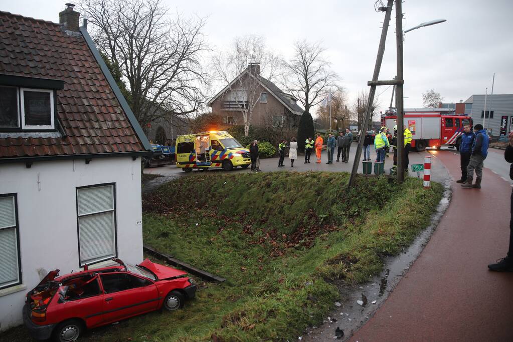 Auto rijdt van dijk en knalt tegen woning