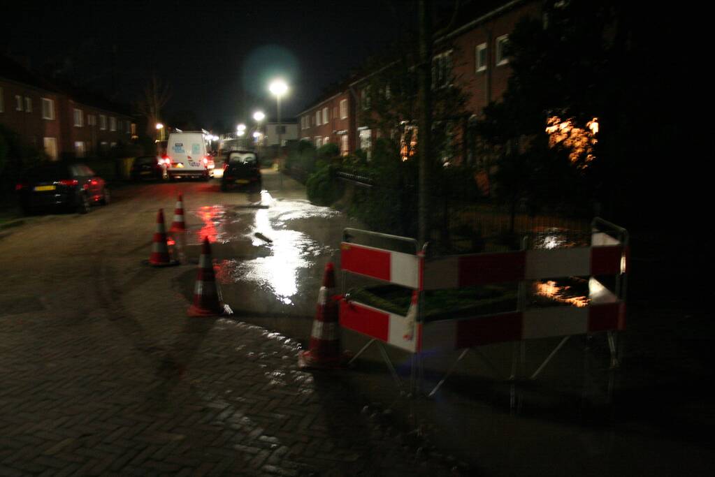 Straat onder water door gesprongen waterleiding