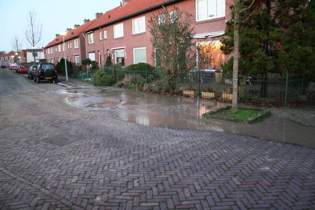 Straat onder water door gesprongen waterleiding