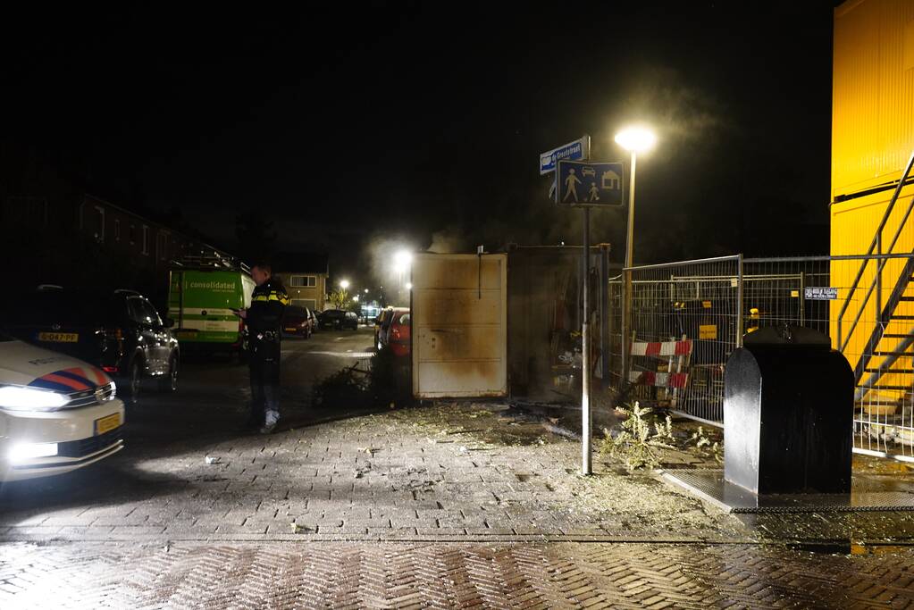 Kerstbomen tegen bouwcontainer in brand gestoken