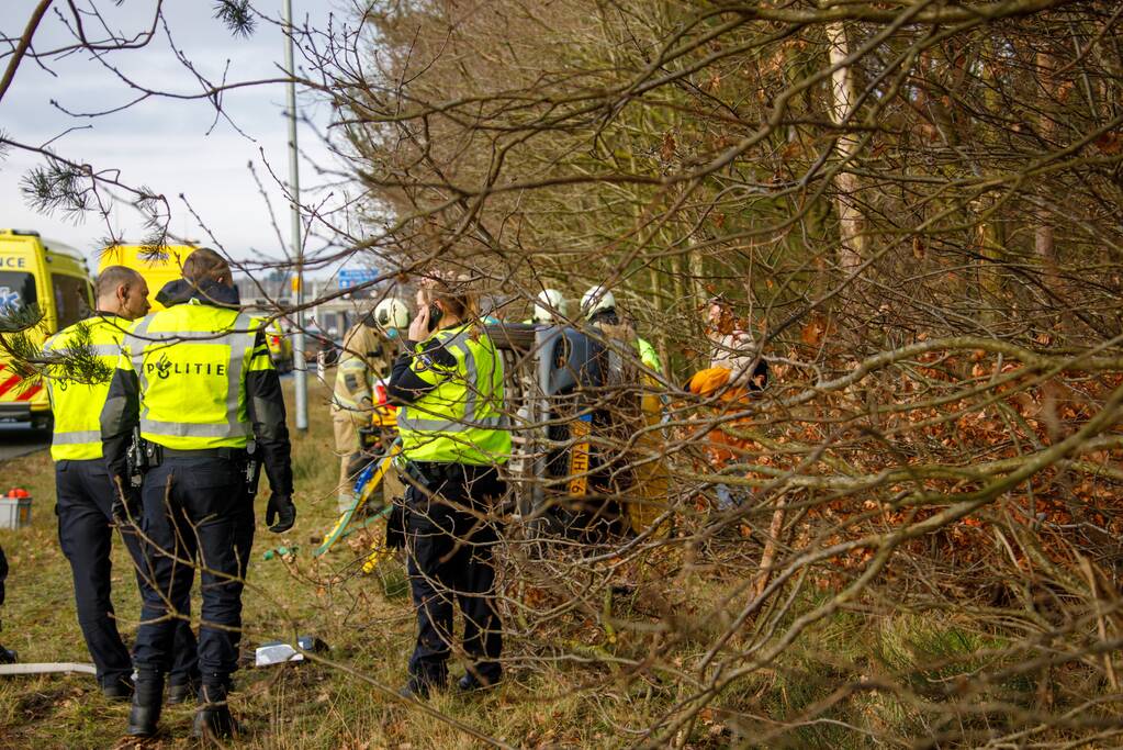 Auto vliegt uit de bocht en belandt op zijn kant
