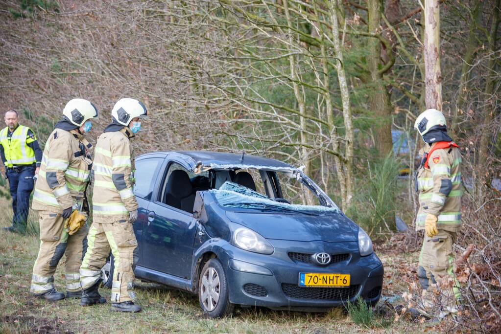 Auto vliegt uit de bocht en belandt op zijn kant
