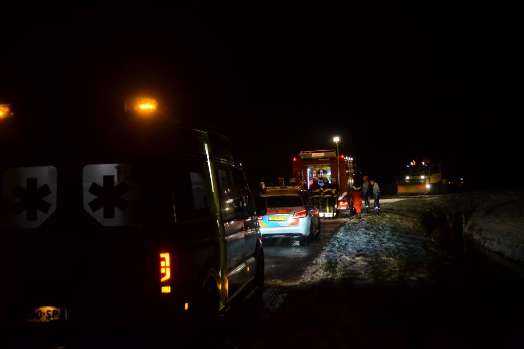 Auto glijdt van de weg en belandt op de kop in sloot