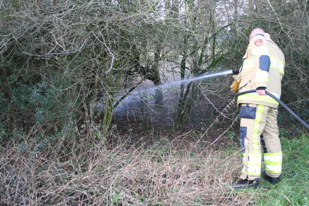 Brandweer blust autoband in bos