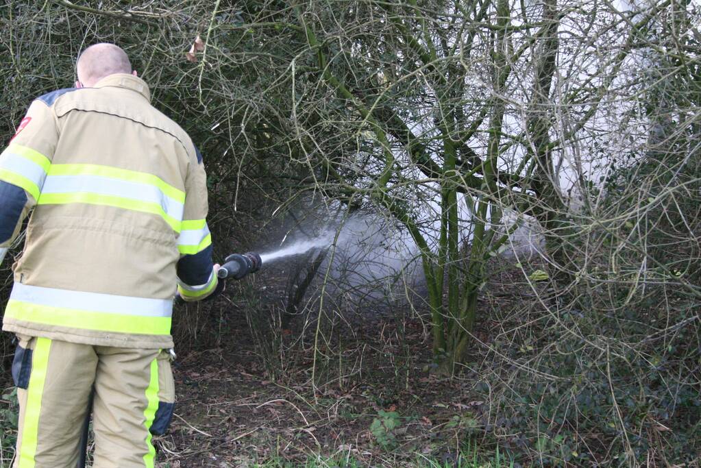 Brandweer blust autoband in bos