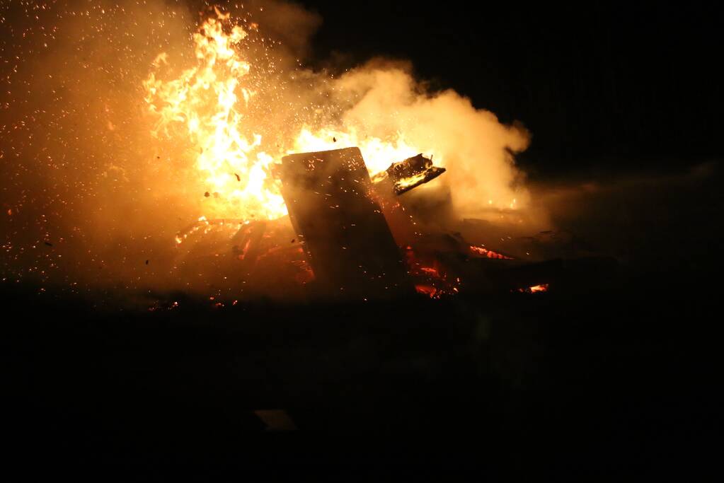 Brandweer blust brandende matras en pallets