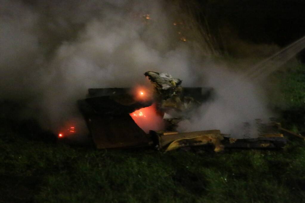 Brandweer blust brandende matras en pallets