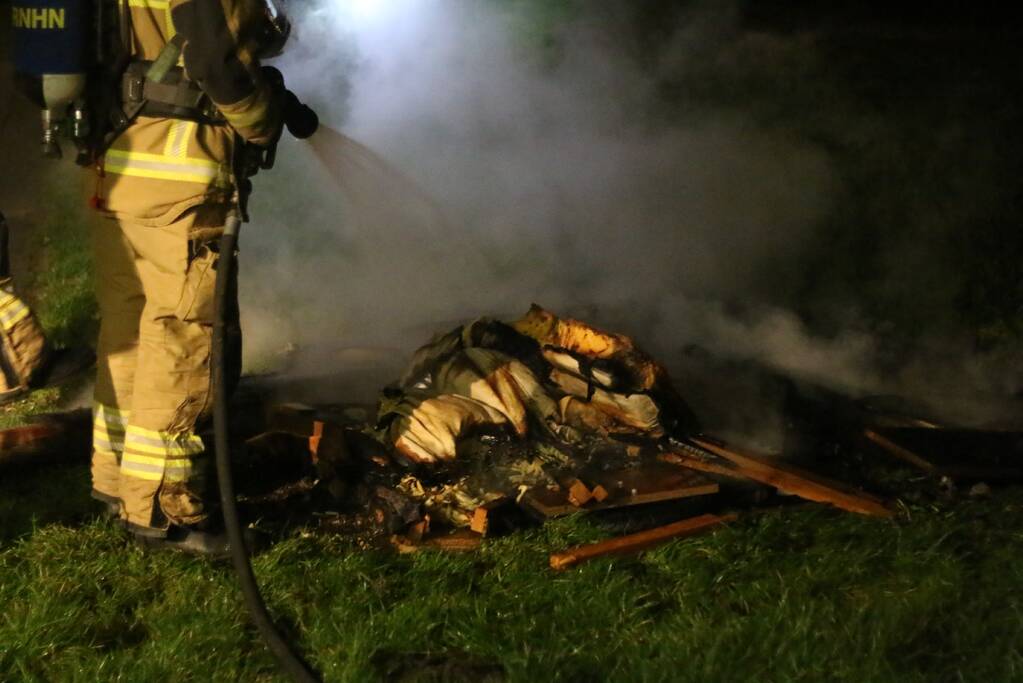 Brandweer blust brandende matras en pallets