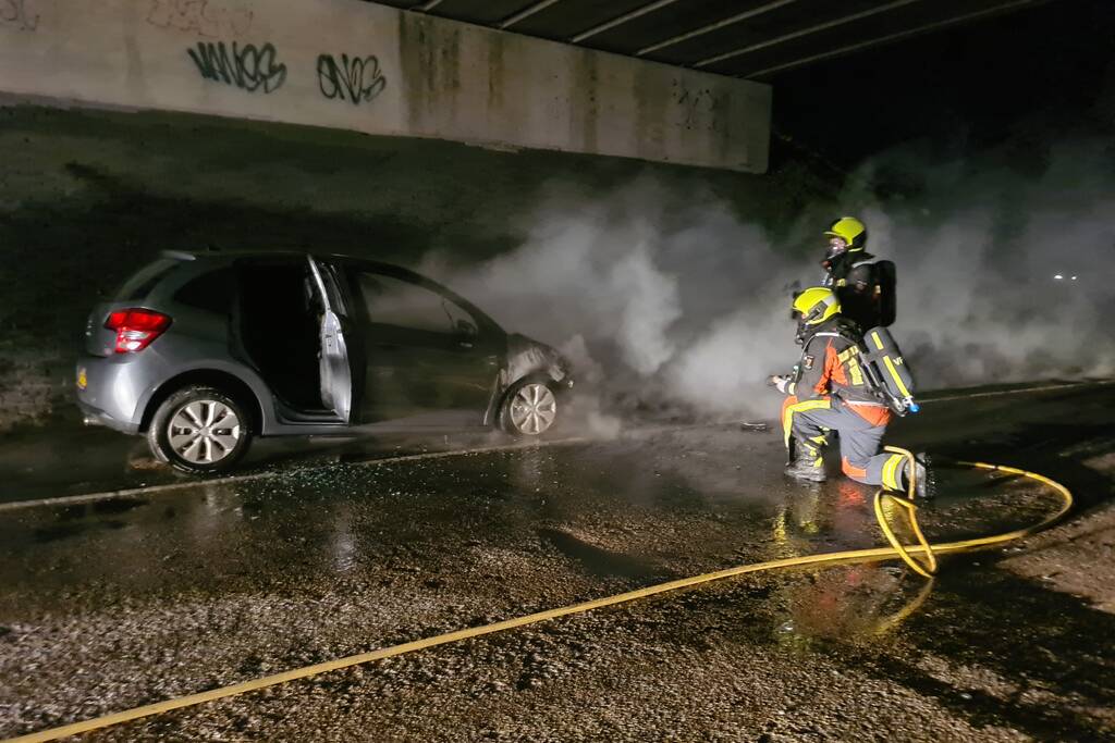 Auto vat vlam onder viaduct snelweg