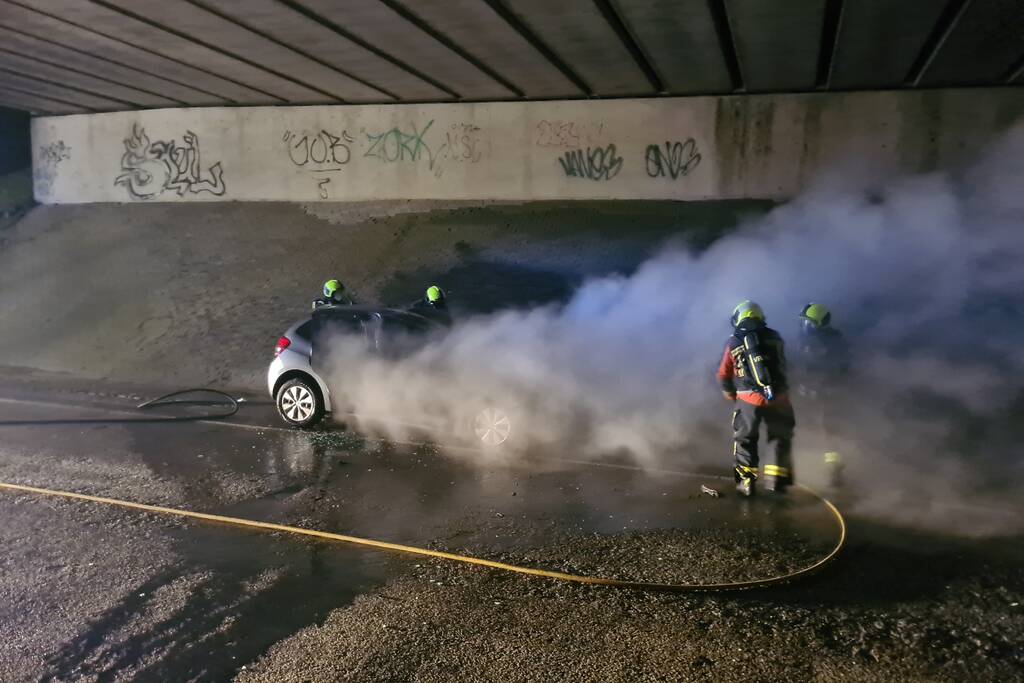 Auto vat vlam onder viaduct snelweg