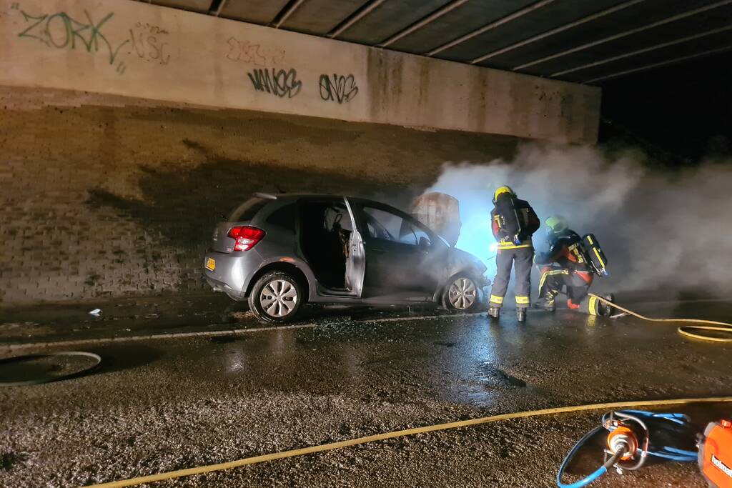 Auto vat vlam onder viaduct snelweg