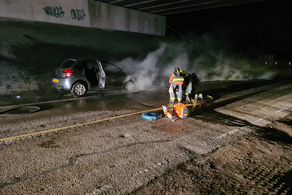 Auto vat vlam onder viaduct snelweg