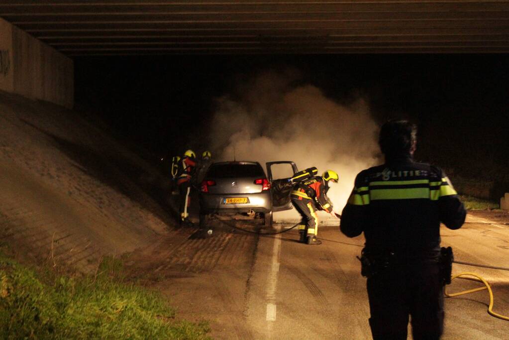 Auto vat vlam onder viaduct snelweg
