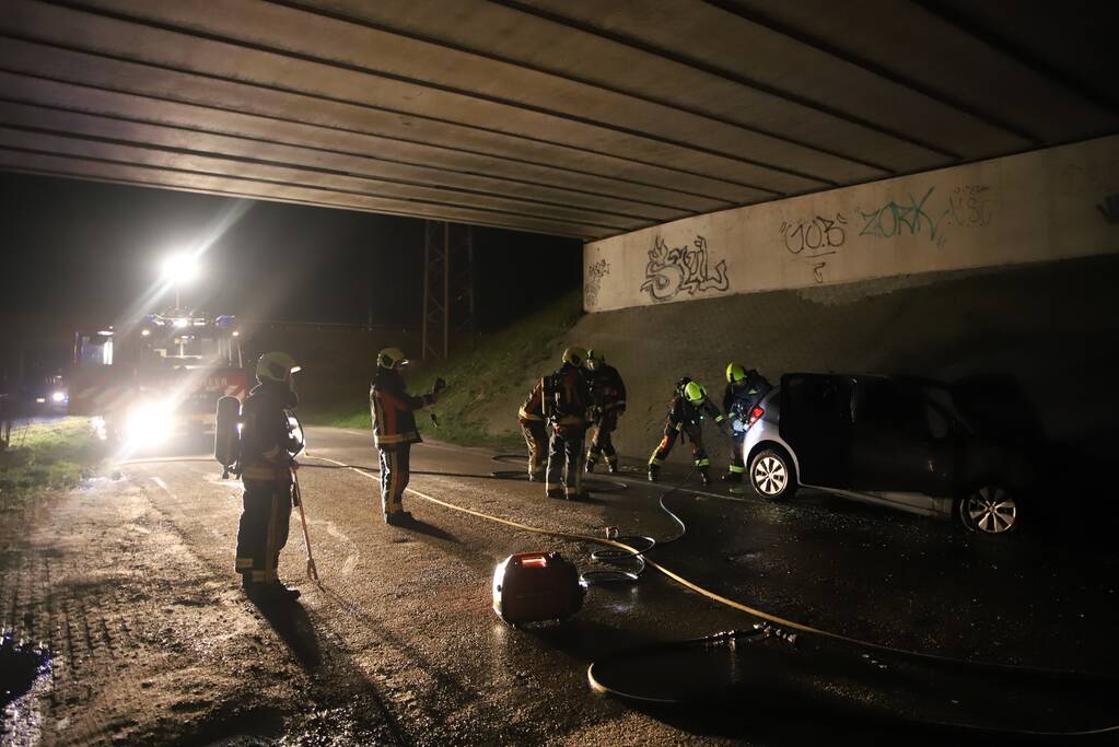 Auto vat vlam onder viaduct snelweg