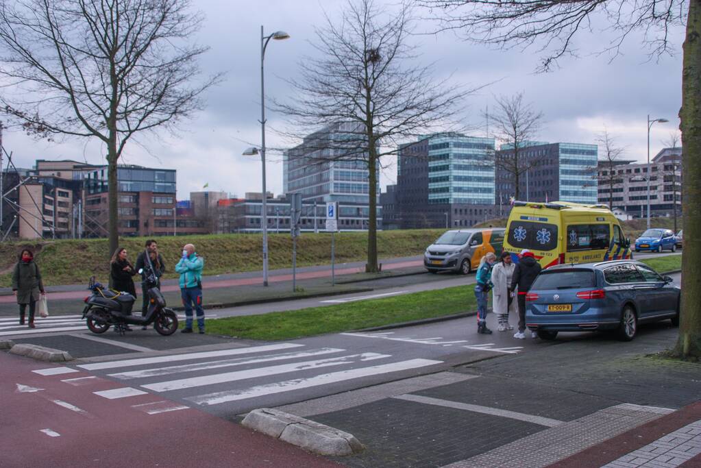 Personenauto en scooter schade na botsing