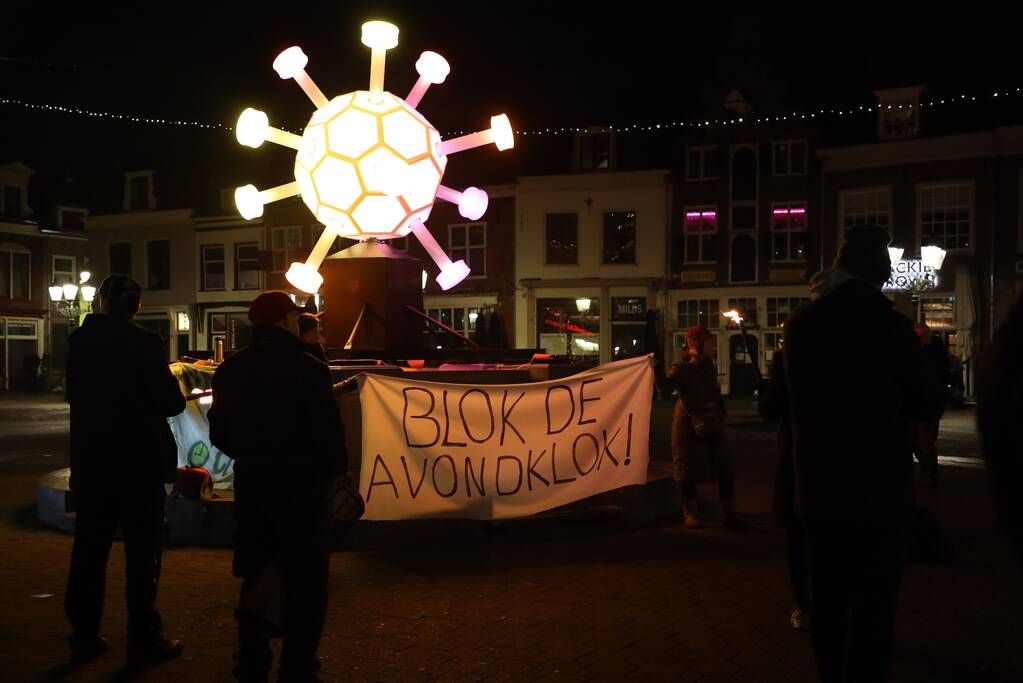Actiegroep Viruswaarheid demonstreren tegen avondklok bij coronavirus-kunstwerk