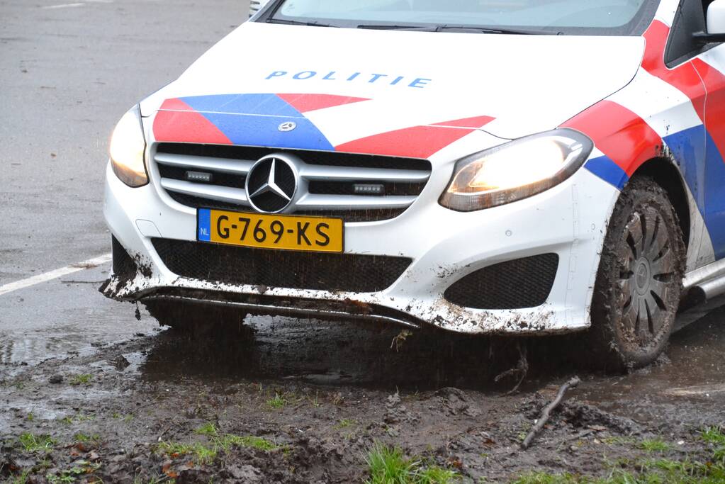 Politieauto rijdt zich vast in modder