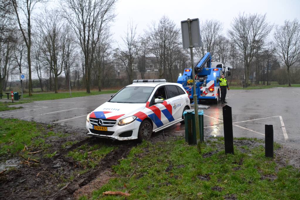 Politieauto rijdt zich vast in modder
