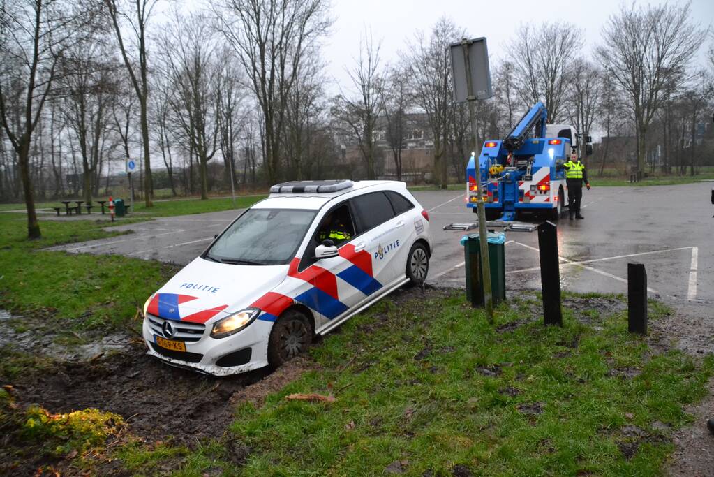 Politieauto rijdt zich vast in modder